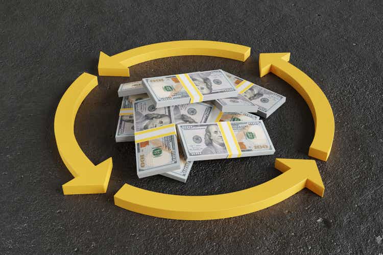 Haufen gestapelter 100-Dollar-Banknoten in einem gelben Kreis aus gebogenen Pfeilen auf Betonboden. Veranschaulichung des Begriffs des Cashflows und der im Umlauf befindlichen Währung