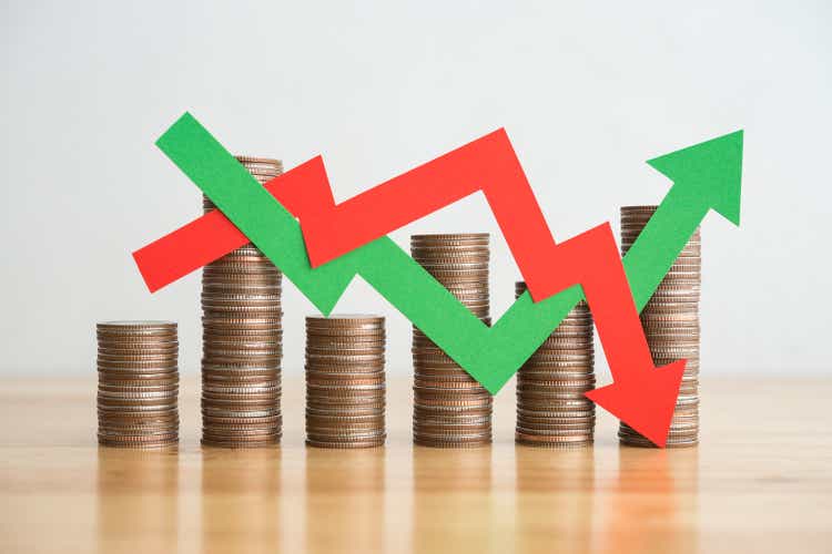 Stacked coins and arrows red green graph chart volatility up and down.