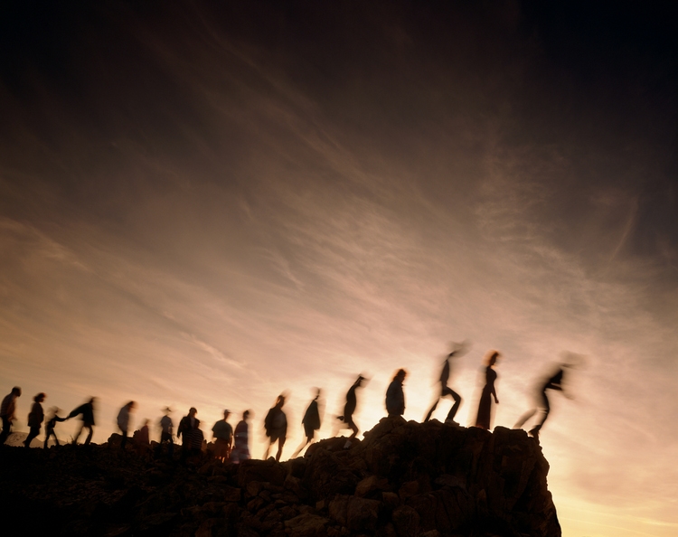 Blurred line of people on the edge of a cliff