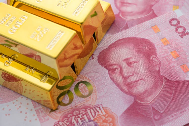 Gold bars on Chinese yuan bill banknotes background.