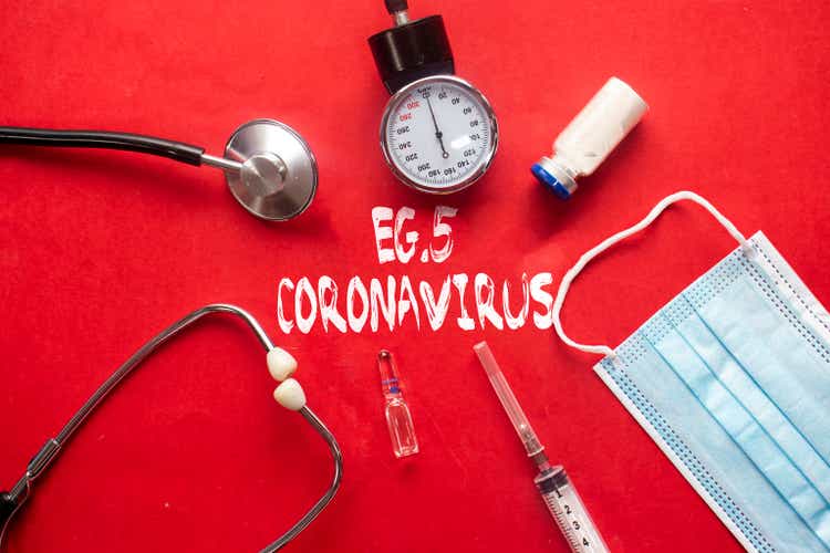 EG.5 Coronavirus text with stethoscope and syringe and vaccine bottle and medical mask on red background. Covid or Coronavirus Concept