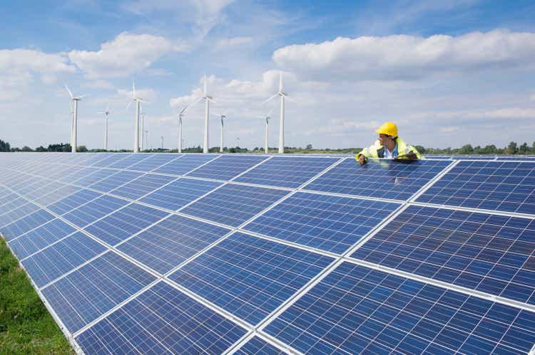 Mixed race man checking solar panels