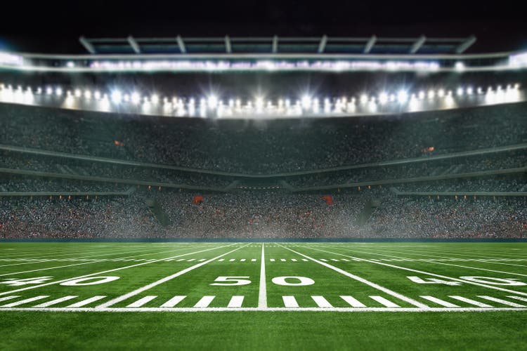 green field in american football stadium. ready for game in the midfield