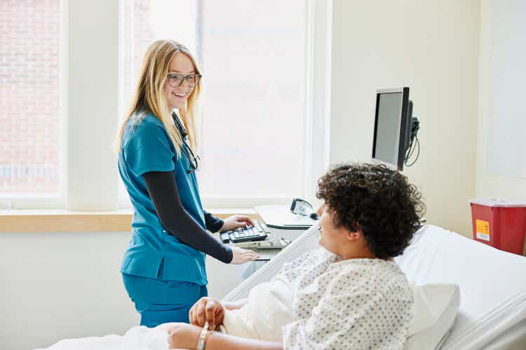 Medium shot nurse consulting with recovering patient in emergency room