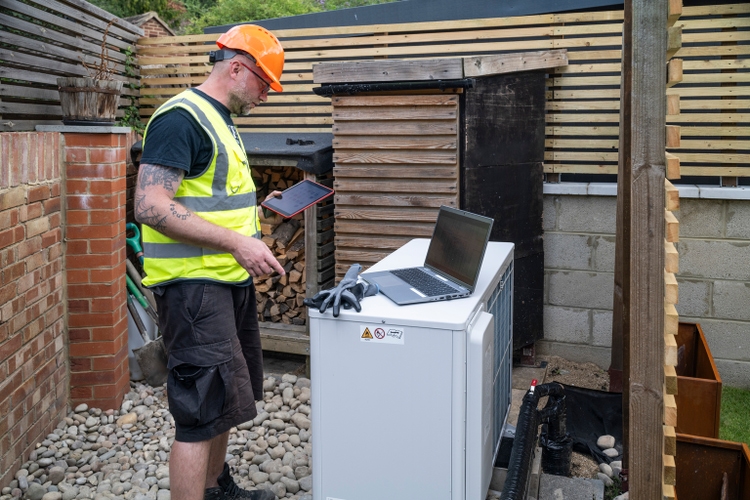 HVAC worker installing air source heat pump