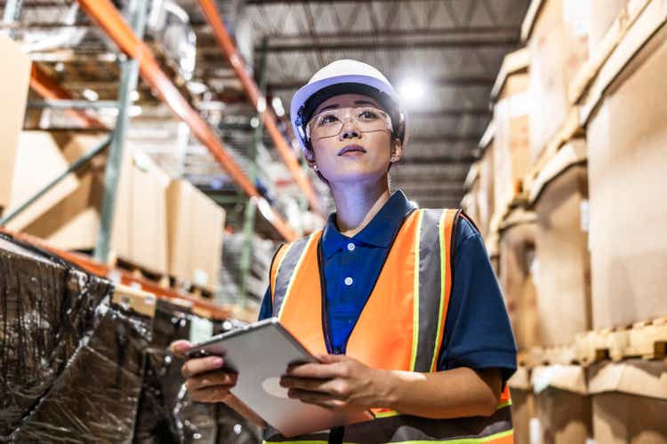 Warehouse employee taking inventory with digital tablet