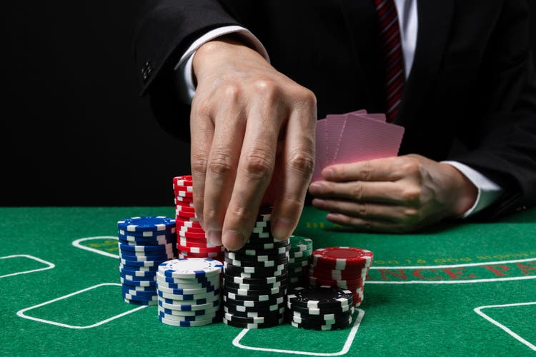 Businessmen holding playing card gamble in casino