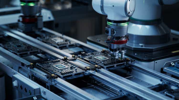 Installation of components and quality control of the black printed circuit.  Fully automated circuit board assembly line equipped with high precision robotic arms in a factory.  Electronic device manufacturing industry