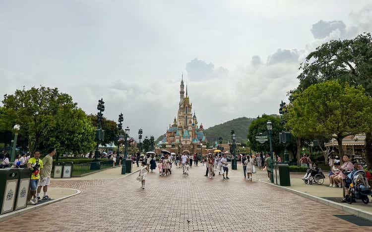 Visitors At Disneyland Resort Hong Kong With Castle of Magical Dreams In Central Area.