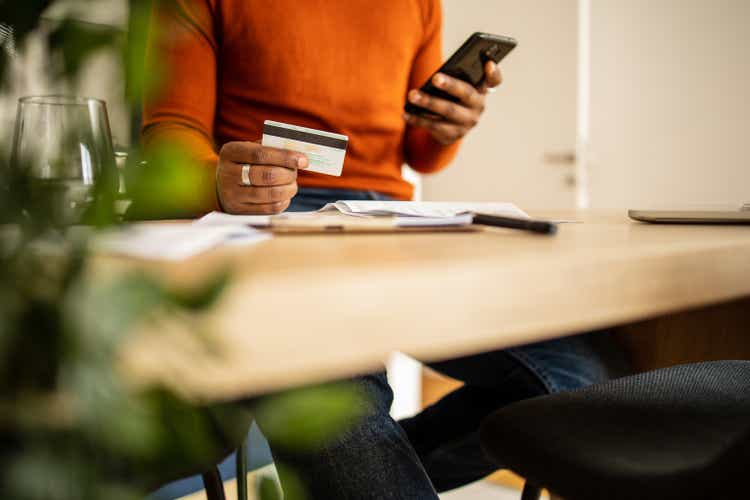 Close up of a African American man paying online.