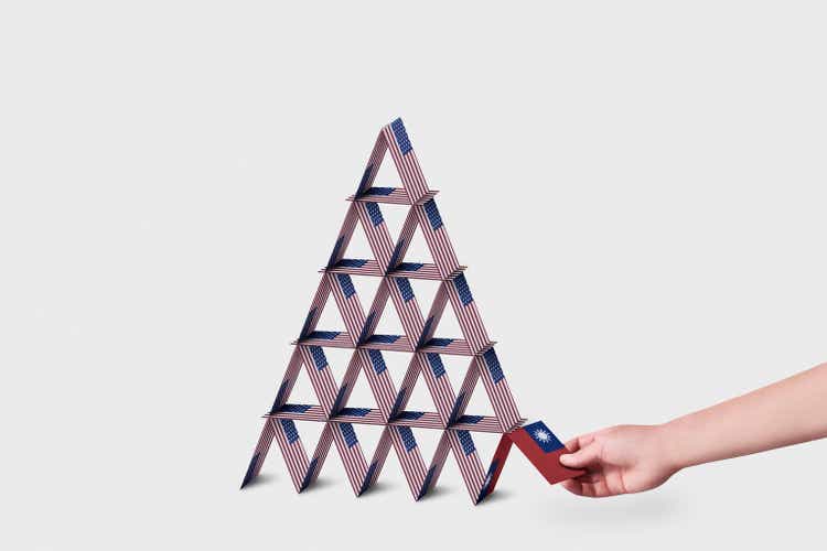 House of cards made out of American flags with a hand grabbing single Taiwanese Flag