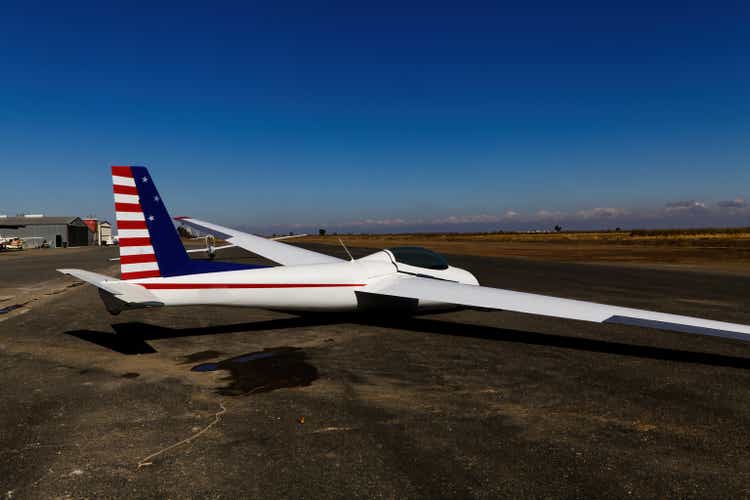 Red White And Blue Glider Sitting On Ground At Airport