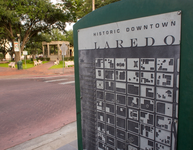 Sign with map of the historic downtown Laredo, Texas, USA, with a park in the background.