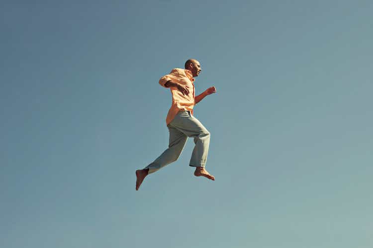 Mature man walking in mid-air against clear blue sky