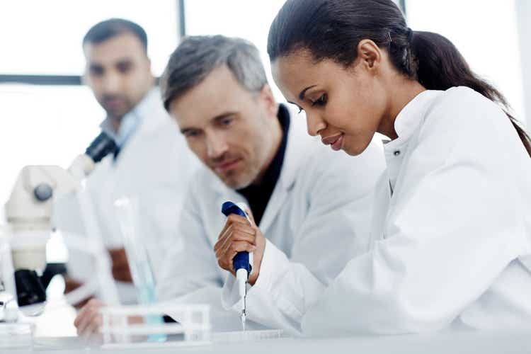 Three scientists examining samples in a laboratory