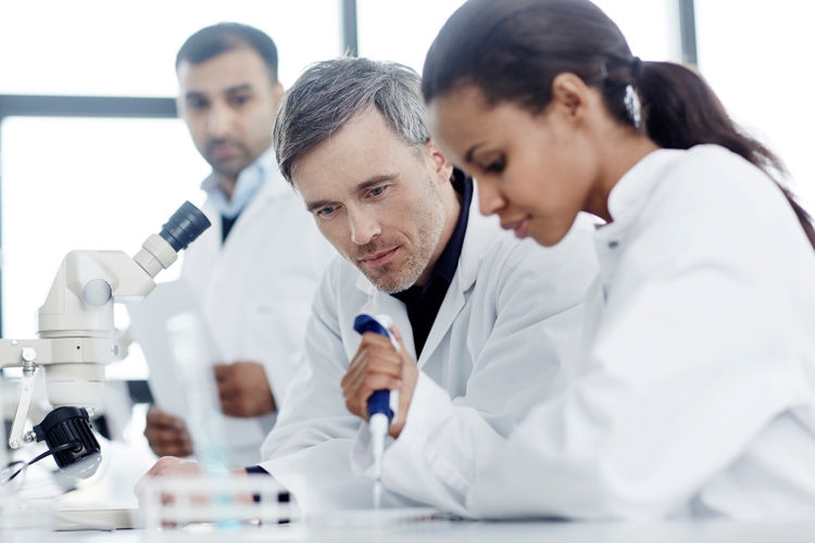 Three scientists examining samples in a laboratory