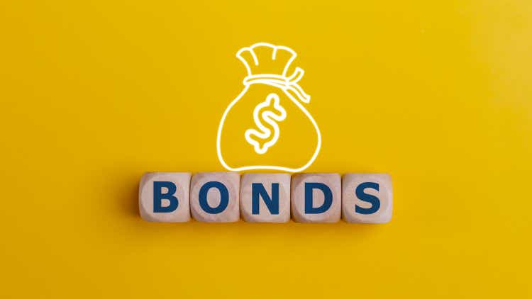 BONDS word on wooden cubes with money bag on yellow background. Bonds increasing concept.