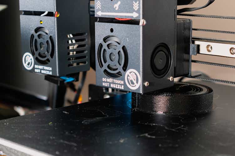 Dual extruder 3d printer printing a black model, idex technology