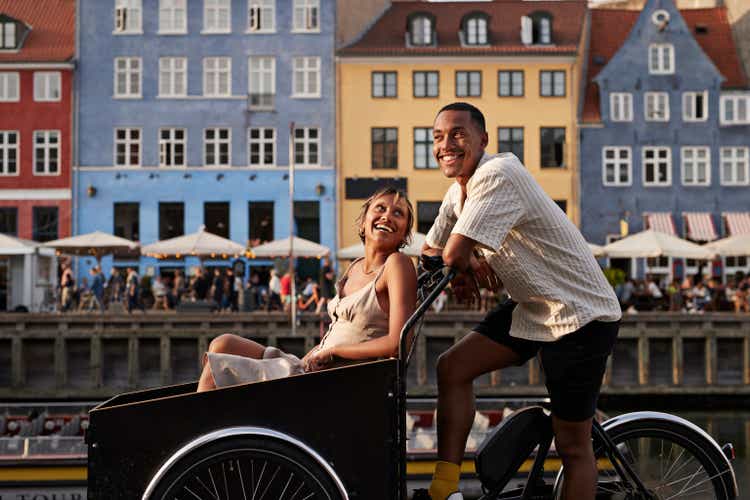 Happy young man with girlfriend in cargo bike