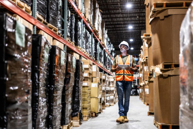 Warehouse employee taking inventory with digital tablet