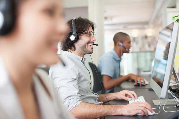 Business people with headsets working at computers in office