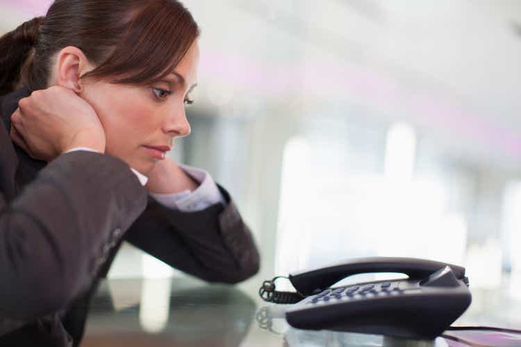 Businesswoman staring at telephone waiting for it to ring