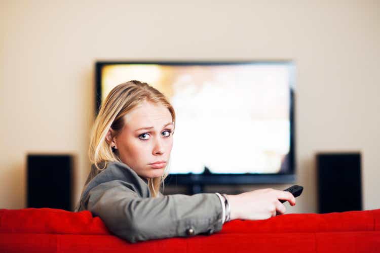 Nothing to watch! Blonde looks round from TV disappointed