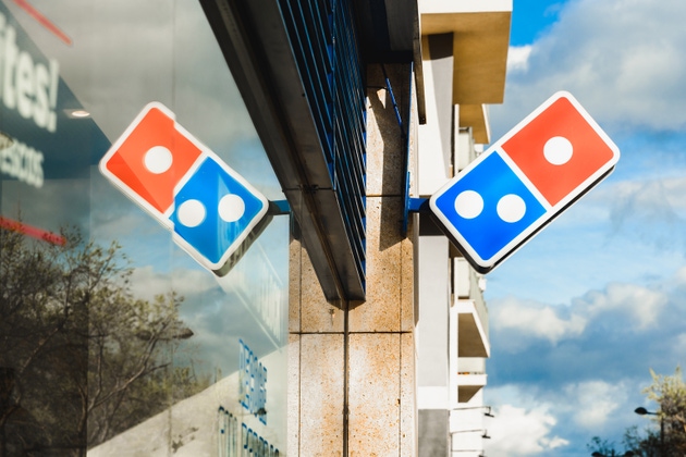Dominos pizza restaurant, with its logo reflected on the glass, in the financial area of Valencia.