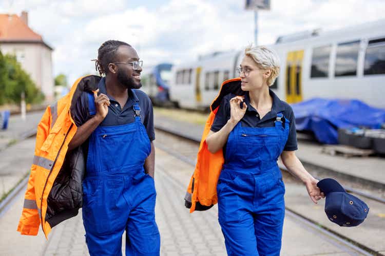 Train engineers at railway station walking and talking outside