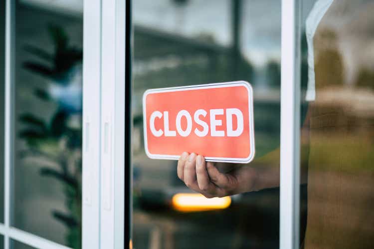 Retail owner of a coffee shop turning closed sign