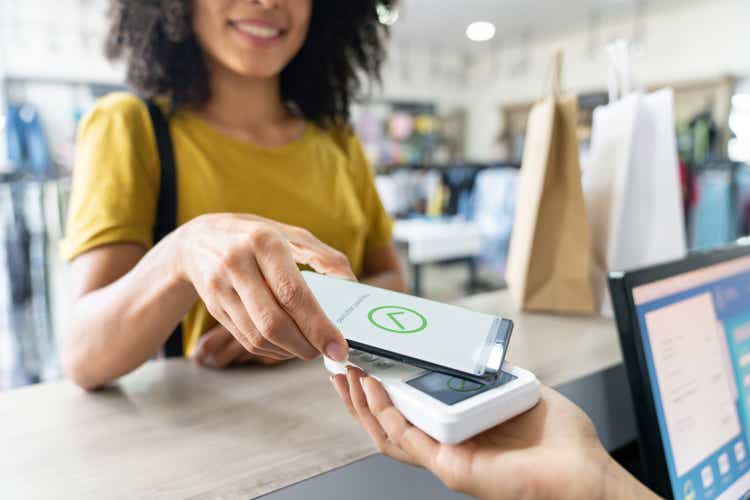 Woman making a mobile payment at a clothing store