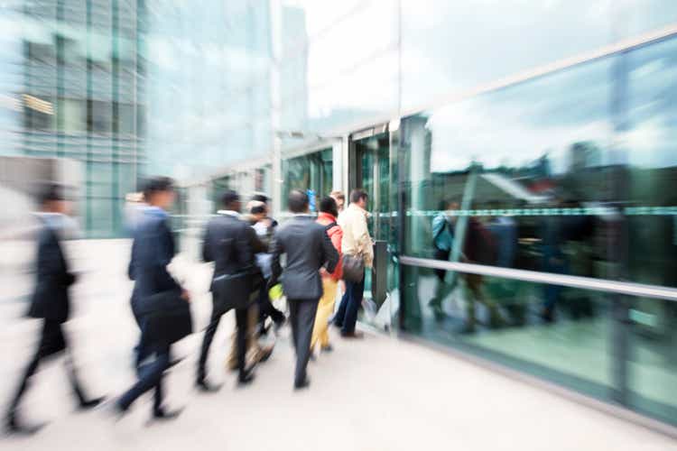 Blurred Business People Entering Office Building Through Glass Doors