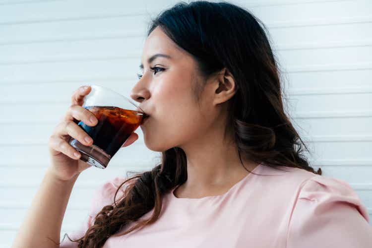 Overweight woman drinking soft drink