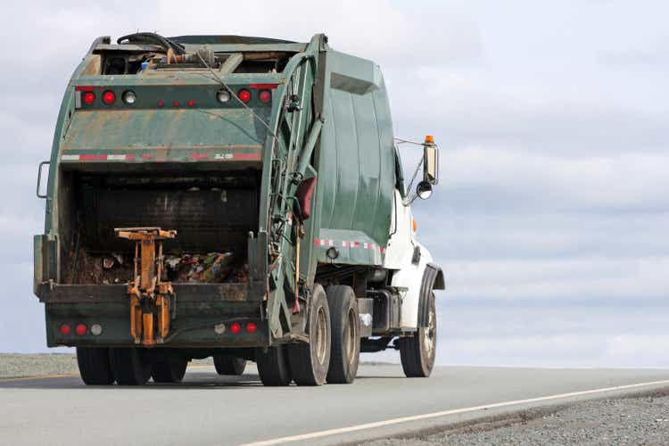 Image of a garbage truck driving down a road