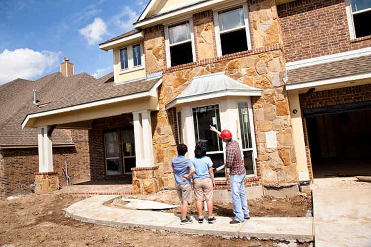 Builder meeting with woman and daughter at new home construction