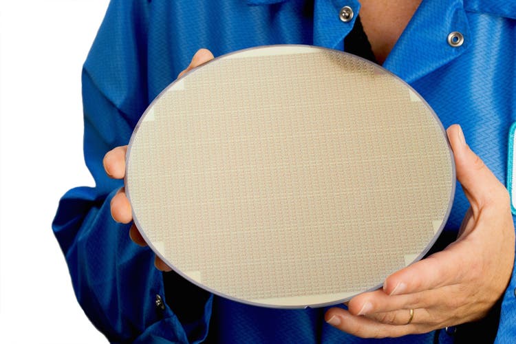 Person in blue holding a large silicone wafer