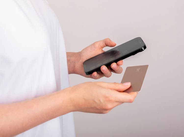 Berlin, Germany September 16 2023 Paying online with bank credit card and mobile phone in hands closeup