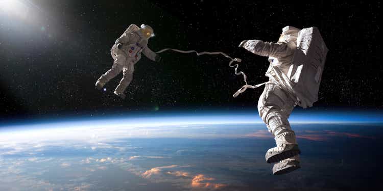 Two Astronauts On Tethered Spacewalk Facing Each Other