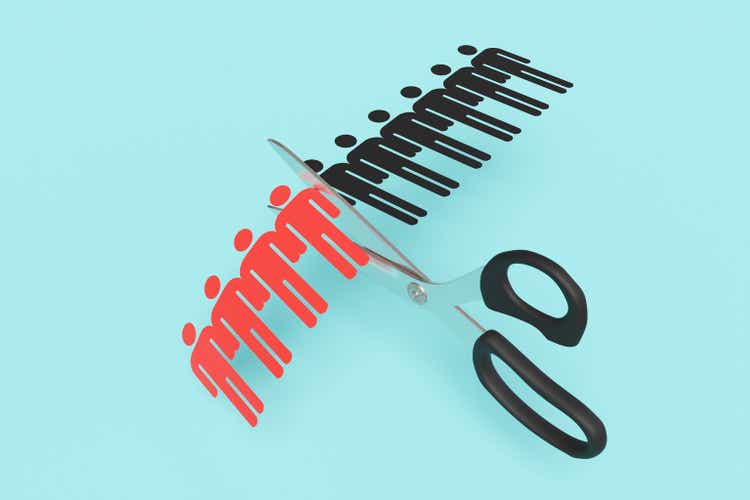 Scissors cutting a paper craft of a row of human shaped outline on blue background. Illustration of the concept of layoff and downsizing of staff