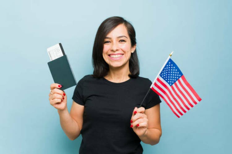 Gorgeous woman feeling patriot with the passport and US flag