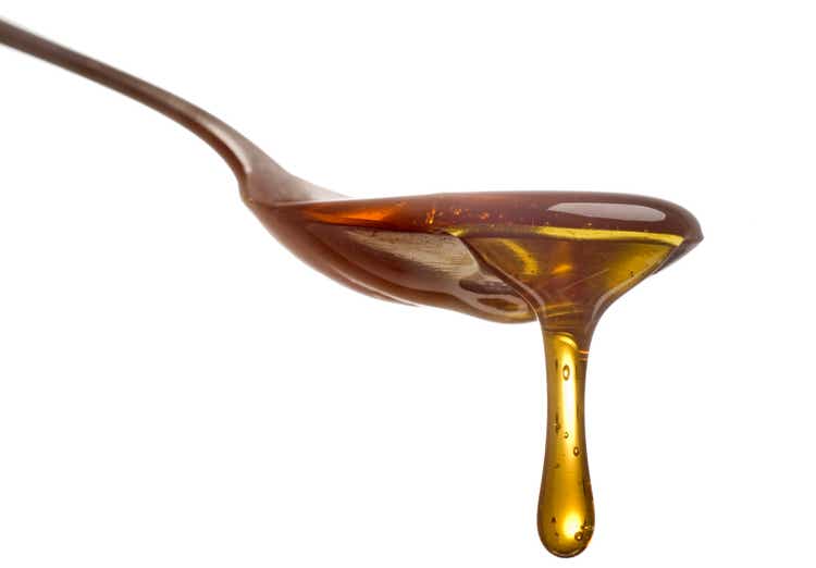 Spoon with dripping sirup or honey close-up