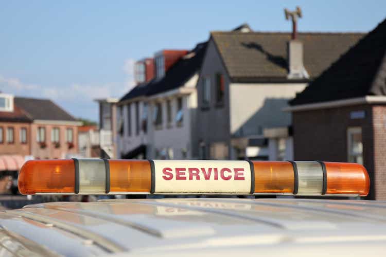 service vehicle with yellow beacon lights in urban area