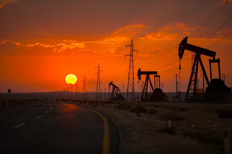 Oil wells and power lines next to the highway.