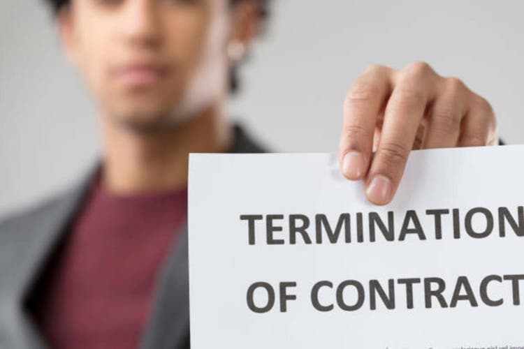 young unrecognizable man presents "TERMINATION OF CONTRACT" noti