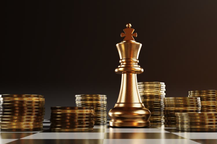 Golden king piece of chess surrounding by stacks of gold coins on a chessboard. Illustration of the concept of the winner of investment and business