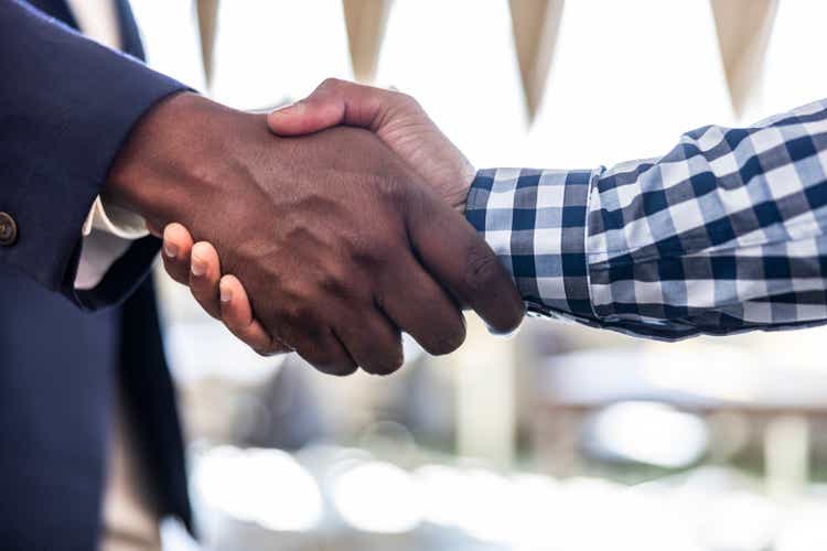 Closeup - Male colleagues shaking hands in modern office