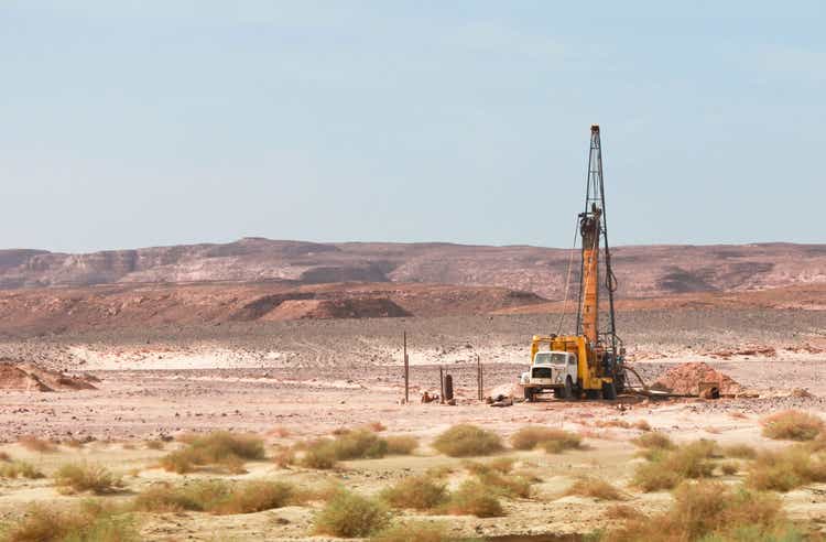 Oil drilling well alone in the middle of sandy desert