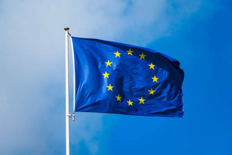 Europe flag fluttering with strong wind and blue sky, blue flag with yellow stars forming a circle