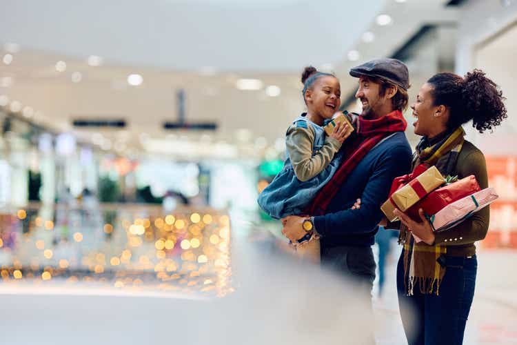 Cheerful multiracial family enjoying in Christmas shopping at the mall.