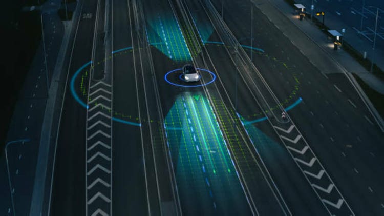 Following Aerial Drone View: Autonomous Self Driving Car Moving Through City Highway. Visualization Concept: Sensor Scanning Road Ahead for Vehicles, Danger, Speed Limits. Evening Urban Driveway